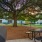 outdoor grilling and picnic area next to hammocks under large tree