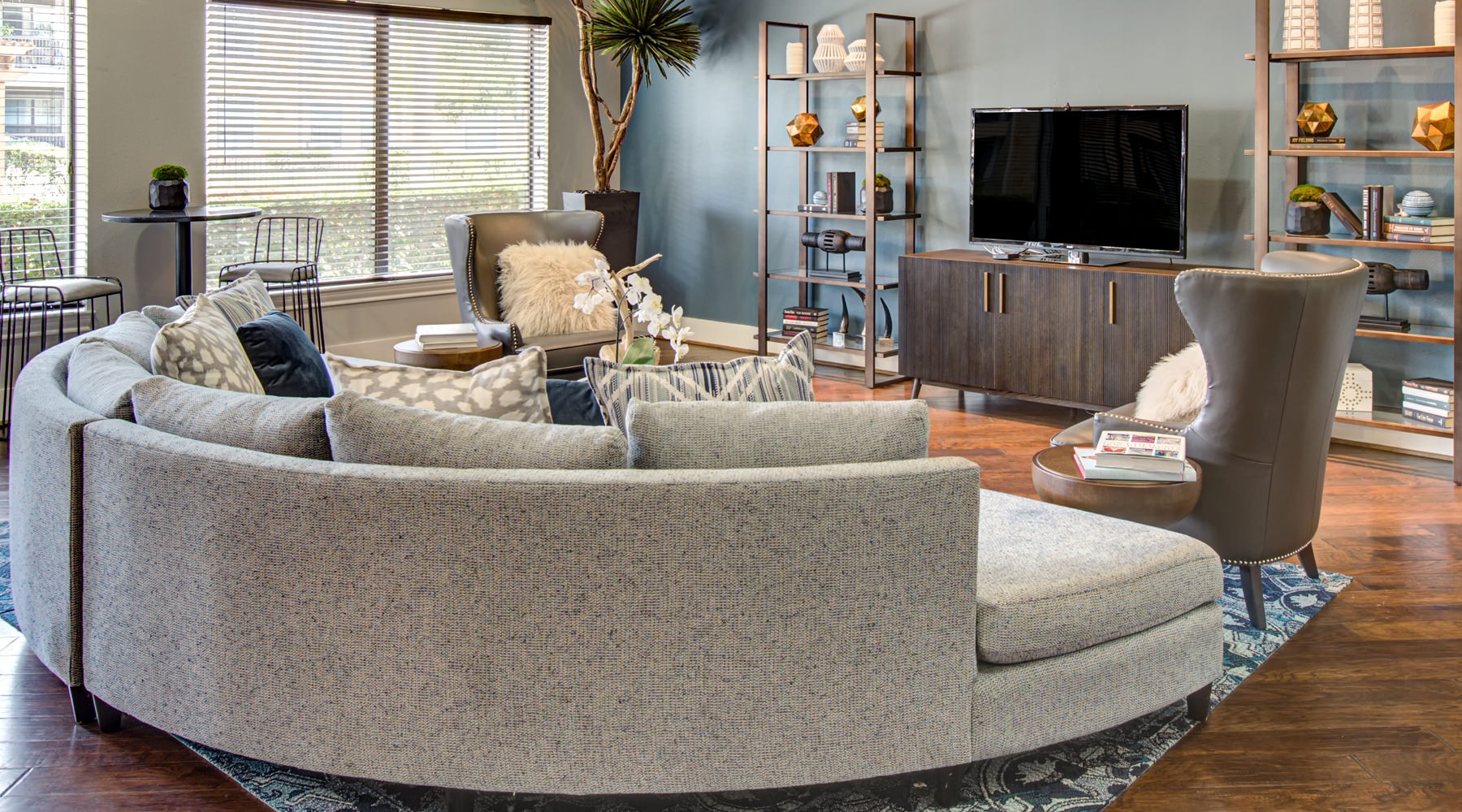 Clubhouse with sectional couch and wall of windows for plenty of natural light.